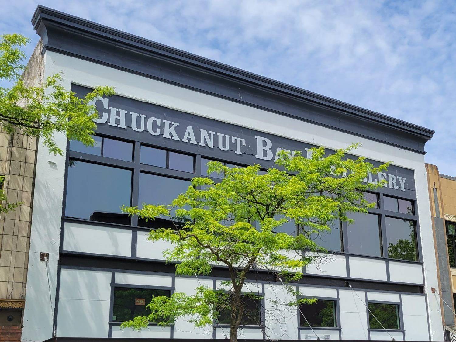 The Chuckanut Bay Distillery building on Cornwall Avenue, its name painted across the facade above tall black-framed windows