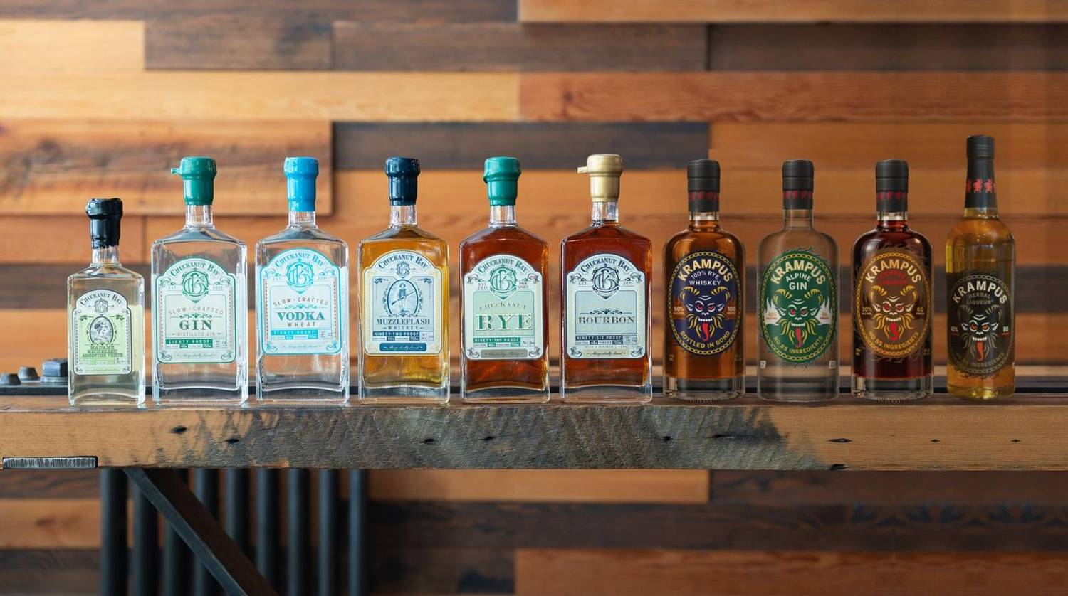 The Chuckanut Bay and Krampus spirits lined up on a reclaimed-wood bar shelf